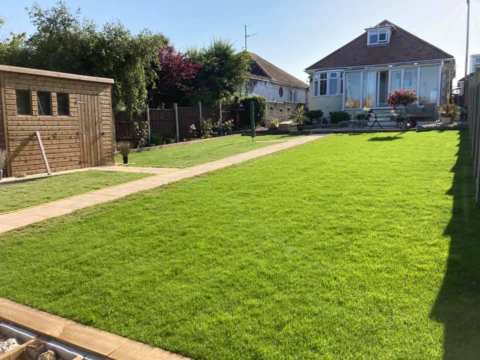 Garden laid with artificial grass with paving stones set in for a path